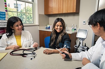 Two doctors checking a patient's blood pressure