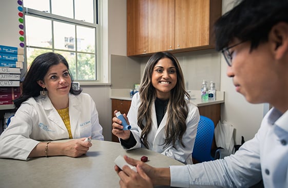 Two doctors and a patient sitting at a table