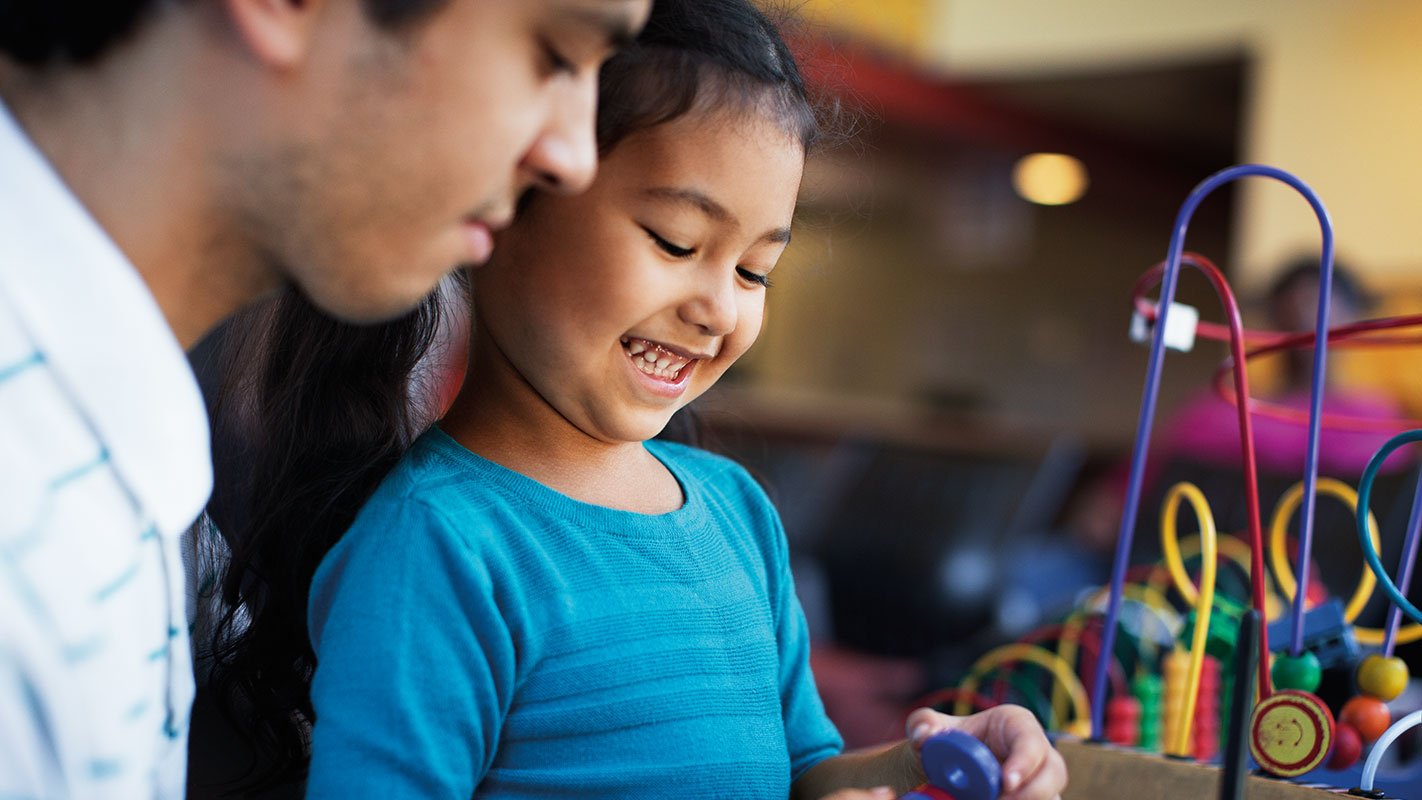 A child smiling in a physicians office play area