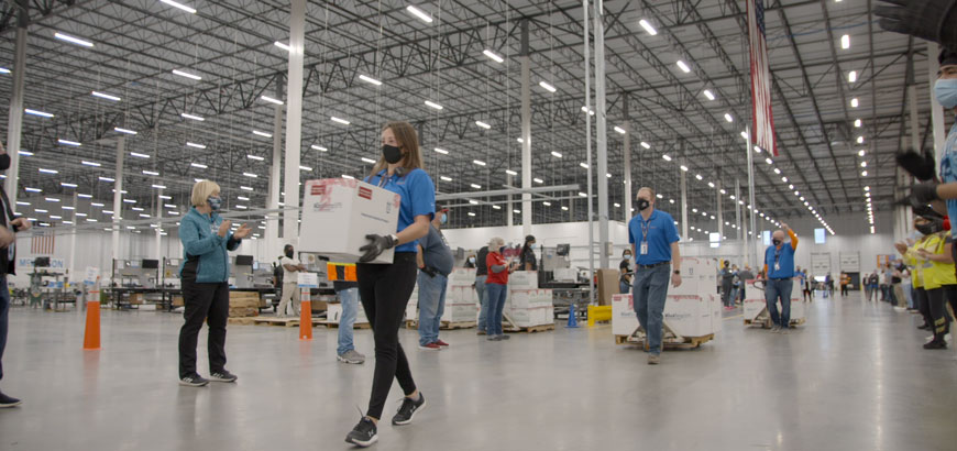 Workers moving boxes and pallets inside a warehouse