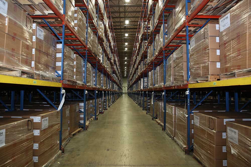 A row of boxes stacked on metal shelves in a warehouse